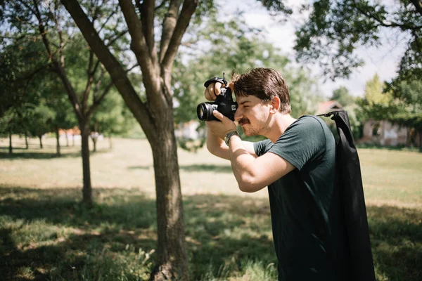 Fotografia de fotógrafo na natureza usando câmera profissional — Fotografia de Stock