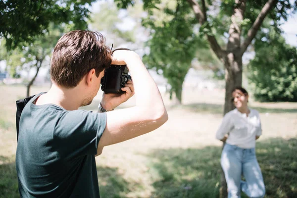 Hombre tomando fotos de chica en el parque —  Fotos de Stock