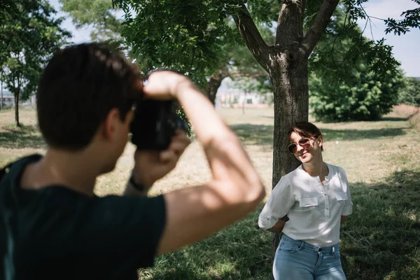 Güzel bir kadının fotoğrafını çeken bir adamın arkası. — Stok fotoğraf