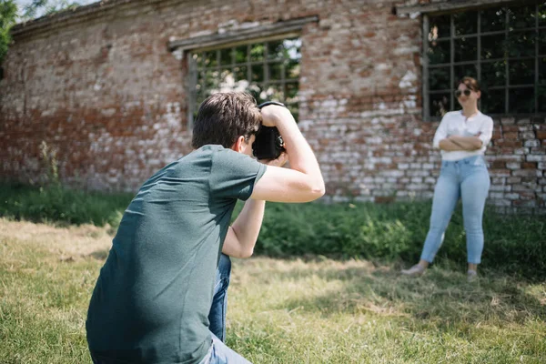 Meisje poseren in de voorkant van het oude gebouw terwijl de man is het nemen van foto van haar — Stockfoto