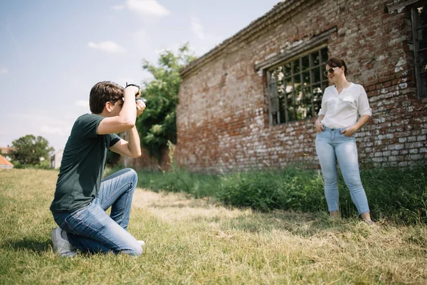 Mężczyzna fotograf fotografowanie a kobieta model w wieś — Zdjęcie stockowe