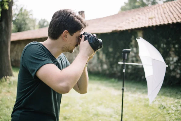 Fényképész néz át a kamera kereső és a fotózás — Stock Fotó