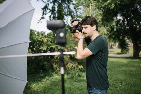 전문 카메라를 사용하여 공원에서 사진을 찍는 사진 작가 — 스톡 사진