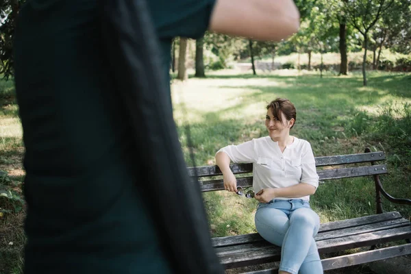 Uśmiechnięta kobieta pozowała podczas kadrowania mężczyzna robi jej zdjęcia — Zdjęcie stockowe