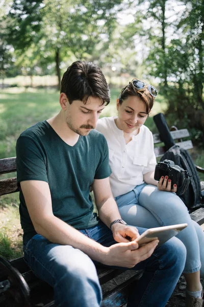 Portrait of woman and male photographer looking at tablet