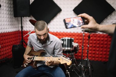 Kesilmiş adam fotoğraf çekerken gitarist çalıyor