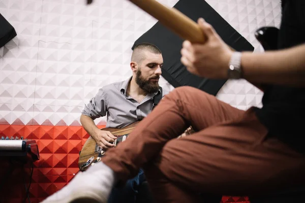 Zaostřený muž hrající na kytaru ve zvukotěsném studiu — Stock fotografie