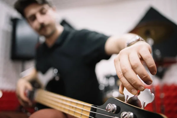 Sfocato musicista maschile accordare la sua chitarra elettrica — Foto Stock