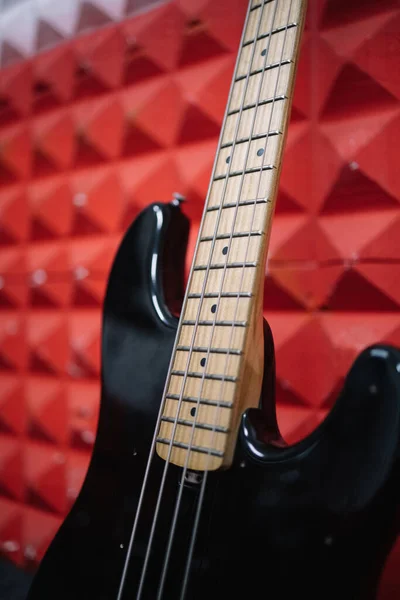 Detailní pohled na lesklou kytaru proti červené stěně — Stock fotografie