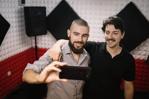 Muži berou selfie při objímání v nahrávacím studiu — Stock fotografie