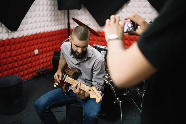 Hombre borroso con smartphone tomando fotos de guitarrista —  Fotos de Stock