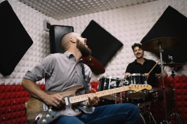 Rock grubu ses geçirmez müzik stüdyosunda kayıt yapıyor.