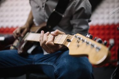 Müzik stüdyosunda gitar çalan bir müzisyen.