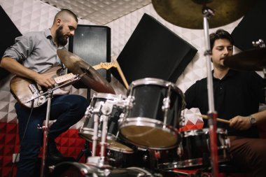 Müzik grubu üyeleri ses geçirmez stüdyoda çalıyorlar.