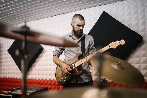 Pohled přes rozmazané činely rockového hudebníka hrajícího na elektrickou kytaru — Stock fotografie