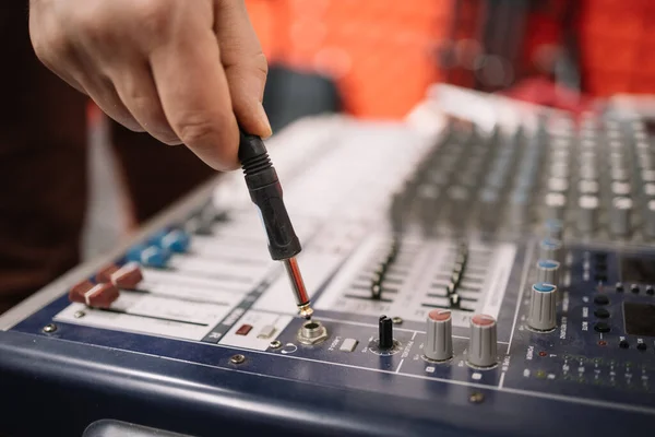 Man hand putitng mannelijke stereo jack in muziek controller — Stockfoto