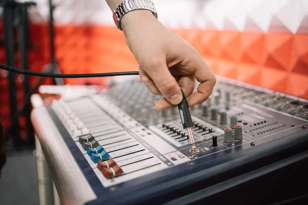 Stříhaný muž ruka uvedení stereo jack do mixéru hudby — Stock fotografie