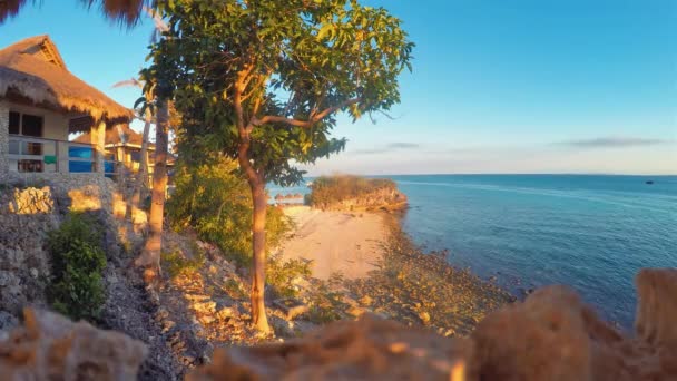 マラパスクア島フィリピンビーチサンセットセブビサヤン海タイムラプスの熱帯ビーチリゾート 観光客 ショアライン上のロッキービーチロックスの近くに海のボートトラフィックとコーラルサンドビーチ上の人々 — ストック動画