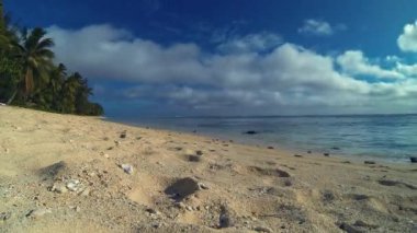 Aitutaki Lagün Resifi Tropik Kumlu Mercan Plajında Sürünen Minik Hermit Yengeç Zaman Atlamalı, Cook Adaları, Polinezyası, Güney Pasifik Okyanusu'nda Bulutlu Mavi Gökyüzü Arka Planda