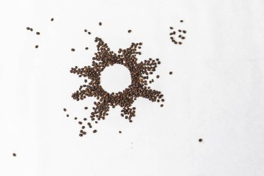 Kahve sağlıklı, ruh halini arttırıcı bir iç. Beyaz bir arka plan üzerinde boş bir orta ile kavrulmuş kahve çekirdekleri Yıldız veya güneş