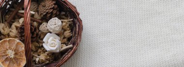 Dekoratif unsurlar ile sepet beyaz sıcak dokusal eşarp veya battaniye yatıyor. Kurutulmuş çiçek, portakal, narenciye, baharat sepetinde. Sonbahar doğurganlık kavramı. Metin için yer. Kopyalama alanı