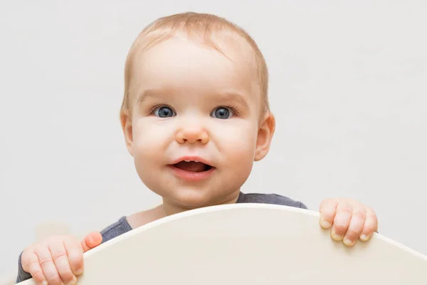 침대에 들고 카메라를보고 흰색 배경에 푸른 눈을 가진 초상화 유럽 백인 행복 미소 아기 유아. 연령 - 10개월 - 1년. — 스톡 사진