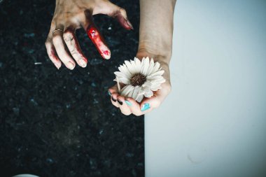 Temiz, güzel bir el kuru bir çiçek tutar, ve süper kirli ikinci overhangs üzerinde kanlı bir leke. Annelik, sağlık, güç ve zayıflık kavramı.