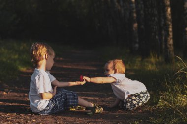 Toddler erkek bir kız bebek örme kalp verir. Aşk konsepti, sevgililer günü.