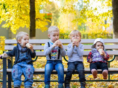 Grup portresi beyaz beyaz beyaz beyaz beyaz beyaz sevimli sevimli komik çocuklar birlikte oturup dondurma yiyorlar. Arkadaşlık eğlence konseptine bayılırım. Sıcak sonbahar ve Hindistan Yazı
