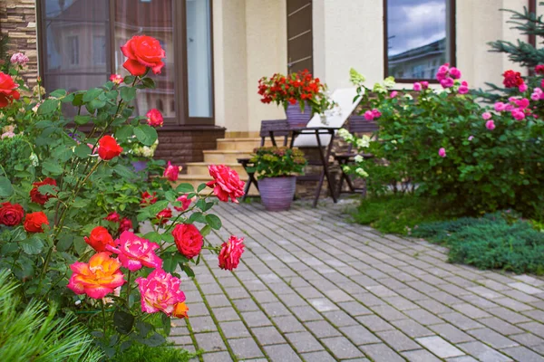 Цветы в вазах у входа в загородный дом, городской дом. Входная дверь с лестницей, украшенной цветущими цветами. Европейский итальянский стиль. — стоковое фото