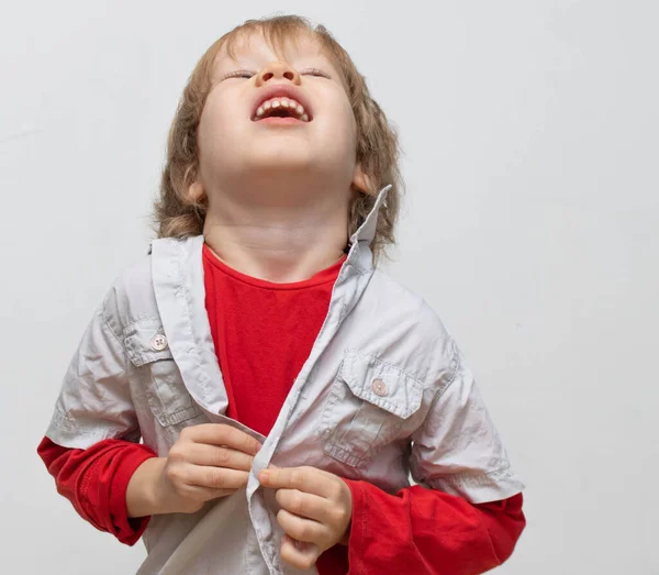 Childhood independence concept, little boy buttoning on shirt, fastening his buttons and crying angrily. The child cannot button and dress himself. The child puts on his own clothes — Stock Photo, Image