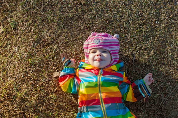 Veselé Batole Dítě Leží Zemi Zimě Barevné Oblečení Bez Sněhu — Stock fotografie