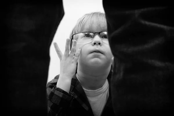 Malý chlapec s brýlemi sedí a zděšeně se dívá na stojícího muže. Domácí násilí, únosy a koncepce zneužívání dětí. — Stock fotografie