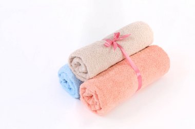 Haddelenmiş mavi, pembe ve beyaz bir arka plan üzerinde bir kurdele ile bej terry havlu,