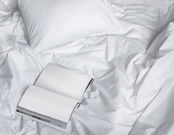 Κάντε κράτηση στο βρώμικο κρεβάτι, δημιουργική σύνθεση φωτογραφιών με το βιβλίο και το λευκό κρεβάτι κάτω από το φως του ήλιου από το παράθυρο — Φωτογραφία Αρχείου