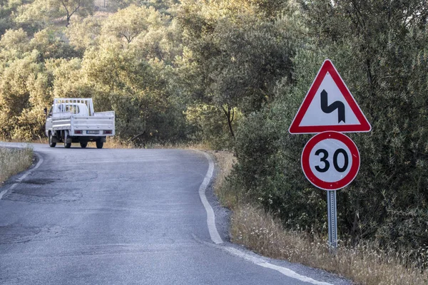 Warning sign on the roadside on the road 30. Pickup truck moving on the road. — Stock Image Warning sign on the roadside on the road 30. Pickup truck moving on the road. Stock Photo