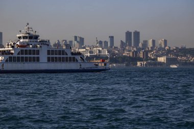 Denizden gelen vapurun görüntüsü. Arka planda gökdelenler.