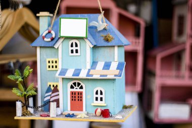 Açık mavi el işi minyatür süs evi desenleri. Çatısında asılı küçük bir bahçesi var..