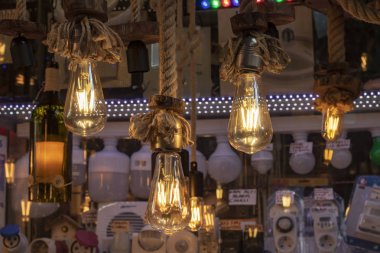 Dükkanın önünde çekilmiş. Halatüzerinde asılı lambalar, kahverengi