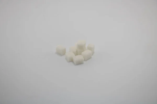 На білому тлі. Деякі кубики цукру . — стокове фото