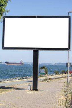 Parktaki kaldırımın yanında bir reklam tabelası var..