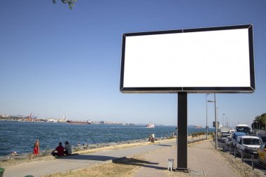 Parktaki kaldırımın yanında bir reklam tabelası var..