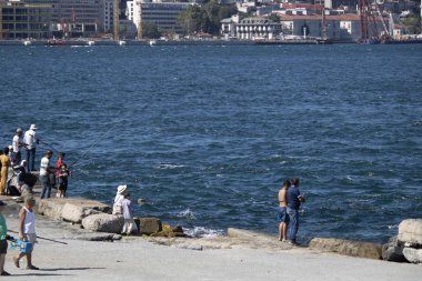 İstanbul, Türkiye - 19 Ağustos 2019: Denizi izleyenler. Denizde bir yat var. Yaz gününde çekilen.