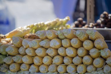 Taze çiğ mısır arka arkaya dizilmiş. Tekerlekli sandalyede satıldı.