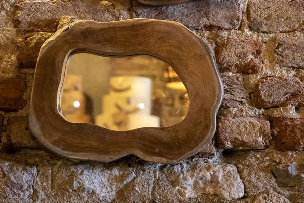 Ahşap çerçeveli ayna. Arka planda eski tuğla duvar.