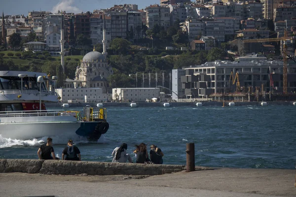 Stambuł, Turcja-Czerwiec-27, 2019: Seascape pochodzi z wybrzeża Sarayburnu, wędkarstwo i spacery ludzi. Tradycyjny parowiec nad morzem i panoramę miasta w tle. — Zdjęcie stockowe