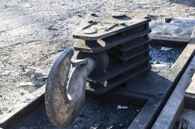 Yerde duran eski ağır yük kancası.