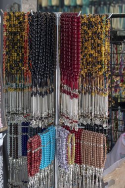 Farklı şekil ve renklerde tespihler asılıyor.