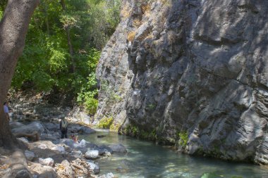 İnsanlar kanyonda akarsu ve yürüyüş yapıyor..