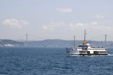 Arka planda İstanbul 'un feribot ve Boğaz köprüsünün görüntüsü.